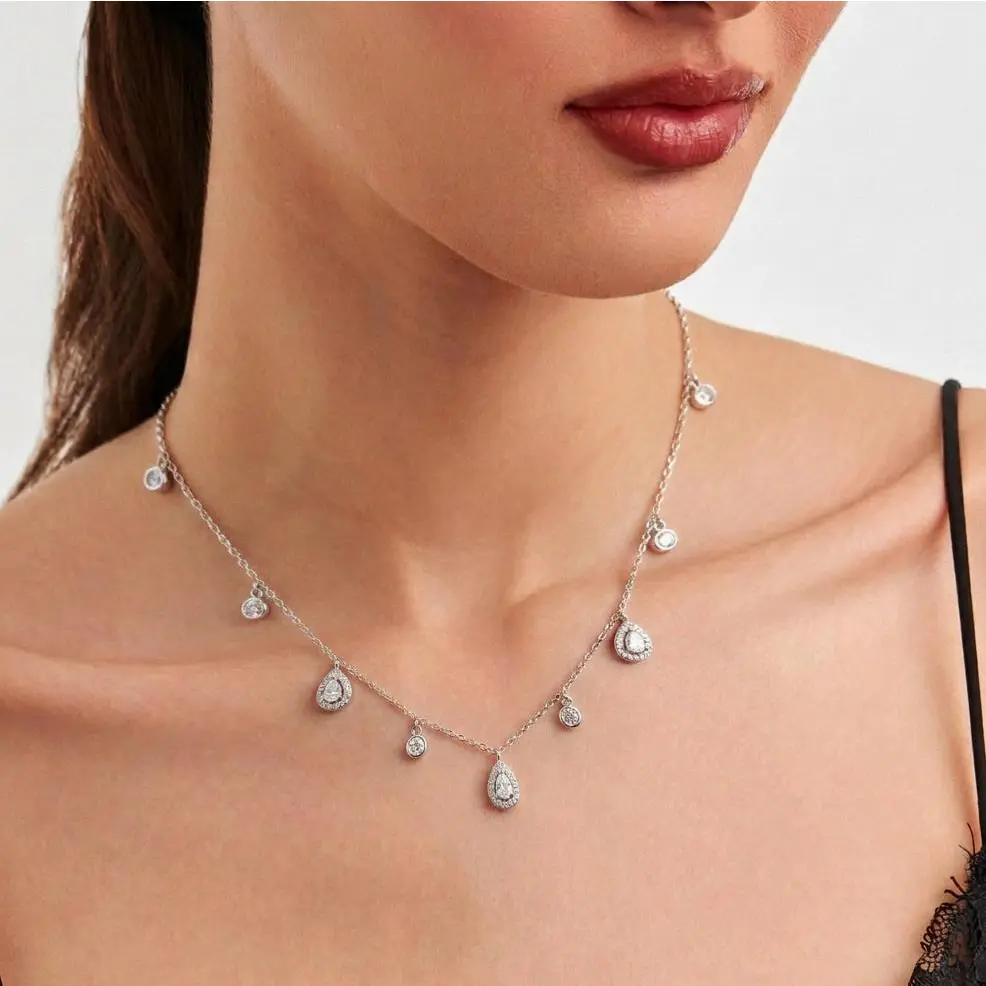 Modelo usando colar gargantilha de ródio com pingentes de cristais e zircônias incolores ajustado ao pescoço, destacando o caimento elegante e o brilho da semijoia de luxo.
